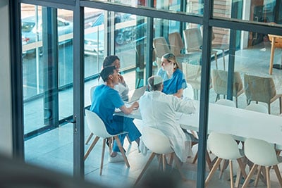 Four doctors talking at a table